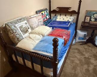 Antique Jenny Lind bed. The bottom railing is stamped JL Hudson, Detroit.