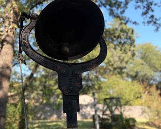 An antique cast iron farm or dinner bell with a yoke marked "American Casting Co" manufactured in Birmingham, Alabama, 1905-1920