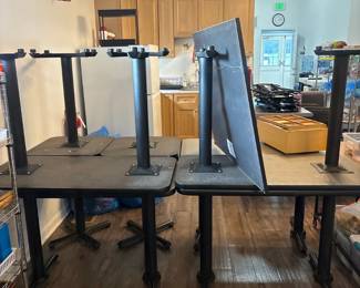 LE054 Group of black pedestal classroom tables shown upside downstacked