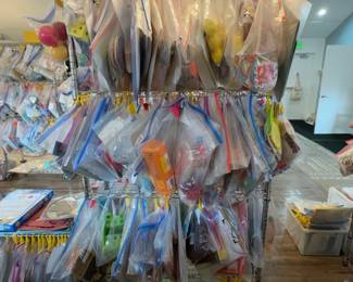 LE019 Rolling wire rack densely hung with individually bagged Montessori lessons