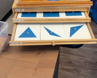 LE049 Montessori Geometry Cabinet with blue geometric insets drawers open showing circles rectangles and triangles
