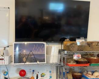 LE035 Large wallmounted flatscreen television above scienceastronomy shelving
