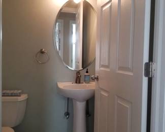 Pedestal sink; mirror; vanity lights