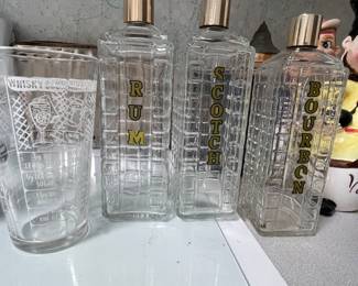 Vintage cocktail shaker with printed recipes, three labeled liquor bottles