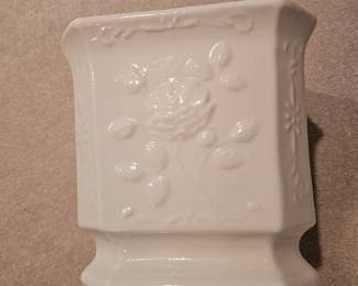 A white glazed ceramic planter featuring an embossed rose design.