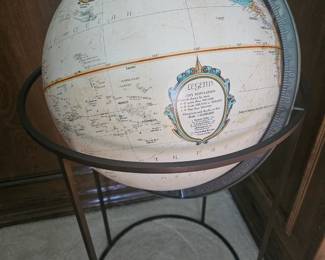 A mid-century modern Replogle world globe on a brass floor stand.