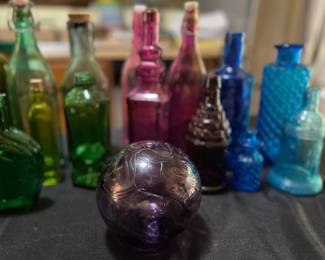 Colored glass bottles, some signed
