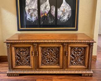 . Hand-Carved Custom Bar Console by Peter Jensen –   Beautiful one-of-a-kind handcrafted wooden bar console, built and hand-carved by Peter Jensen, including both the front and back.  The craftsmanship is incredible, featuring deeply carved decorative panels, ornate trim, and a warm wood finish. The cabinet opens to generous storage with shelving and center drawers—perfect for liquor, glassware and bar accessories.  Measurements: 71.5” wide × 18” deep × 30” tall  A substantial statement piece that could also be used as a buffet, sideboard or credenza.  Very heavy—buyer will need help moving. Decor and artwork not included.