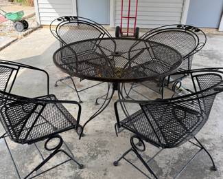 Black wrought iron mesh patio table with four chairs
