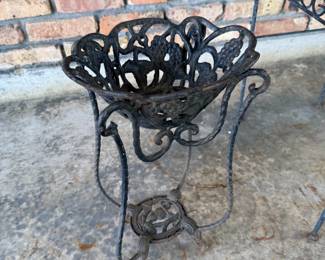 Wrought iron scrolled plant stand with grape leaf basket