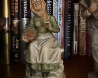 Porcelain figurine of hooded elderly woman with basket