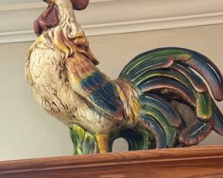 Ceramic rooster figurine with painted feathers on cabinet top