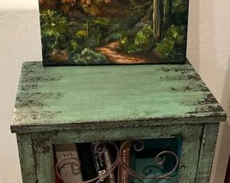 Small Storage Cubby Shelf With Books And An Original Landscape Painting.