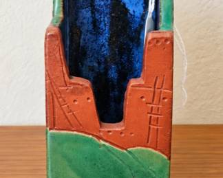 Southwestern pottery holder with Pueblo-style design and rich blue-green glaze.