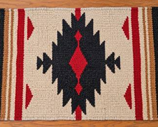 Southwestern woven rug with bold geometric pattern and fringe.