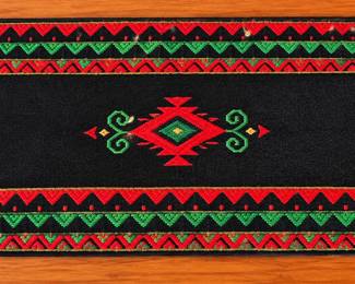 Southwestern woven table runner with bold geometric design and tassel trim.
