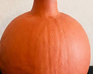 Orange terracotta-style round vase with a narrow neck and rustic finish.