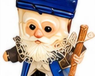 Small character figurine wearing a blue hat and carrying a walking stick.