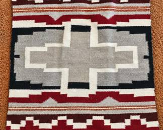 Southwestern woven rug with bold geometric pattern in burgundy, cream, gray and black.