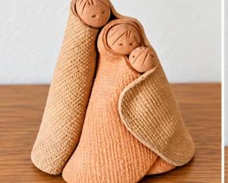 Handcrafted clay family figurine with textured detailing.