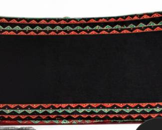 Black textile with colorful red and green geometric border design.
