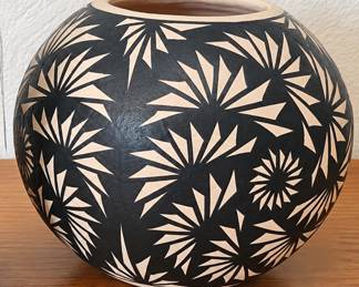 Southwestern pottery holder with blue-green glaze. Black-and-white pottery vase with bold geometric design.