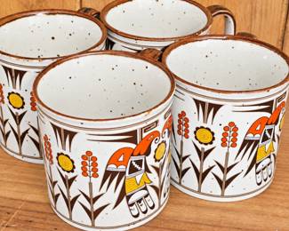 Coordinating ceramic mugs featuring a bold Southwestern bird motif, florals and rustic brown edging.