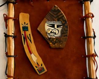 Southwestern-style wall art with leather backing, rustic wood frame, and Native-inspired decorative accents.