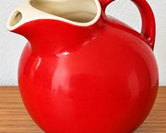 Bright red ceramic pitcher with cream accents.