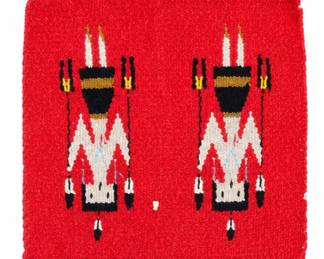 Small red woven textile with two stylized Southwestern figures and fringe detail.