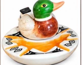 Whimsical ceramic duck figurine displayed on a decorative dish