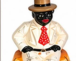 Decorative seated gentleman figurine wearing a white suit, red tie and top hat.