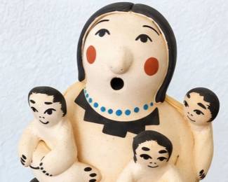 Seated Storyteller Figure — Hand-painted pottery figure surrounded by several children, with cream, black, red, and blue accents.