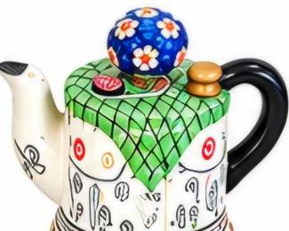 Whimsical ceramic teapot with colorful patterned details and sculptural accents