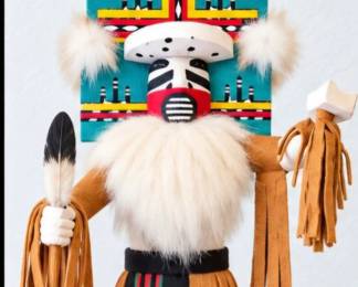 Kachina-style figure with turquoise geometric headdress, white fur accents, leather fringe and colorful painted details.