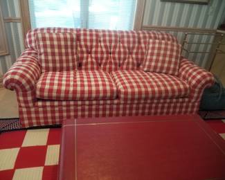 Plaid couch detail; red shagreen coffee table; checked area rug 