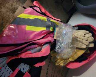 pink and yellow high-visibility reflective safety vest alongside work gloves and a hard hat.