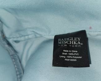 This is a light blue and white colorblock bucket bag by Badgley Mischka New York from the Rae collection, featuring gold-tone hardware and a drawstring closure.
