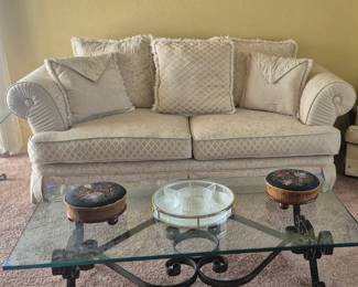 White formal sofa with pillows. Wrought iron coffee table with beveled glass top. 1830s to 1840s footstools