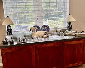 Nice sideboard with glass, acrylic and Metlox dishes  and a pair metal lamps.