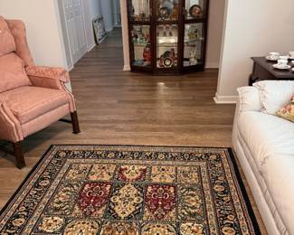 Rug, lighted display cabinet, white leather couch