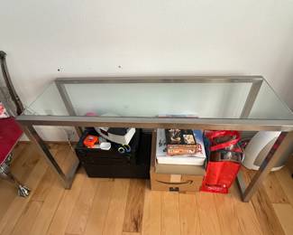 glass-top console or sofa table with a polished metal frame