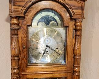 Beautiful circa 1991 Sligh Grandfather Clock, made in Holland, Michigan, USA. Features a gorgeous oak case with ornate carved detailing, moon phase dial, three brass weights and pendulum. In excellent working condition with a beautiful, rich chime. Registered in 1991. A wonderful statement piece with classic Sligh craftsmanship.
