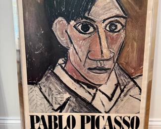 Vintage 1980 MoMA Pablo Picasso: - "A Retrospective "Museum of Modern Art Exhibition Poster, 1980 | Vintage exhibition poster features a striking Picasso portrait rendered in his unmistakable modernist style, with bold black outlines and muted brown, rose, cream, gray tones. Professionally presented under glass with a sleek metallic-tone frame, giving it a strong pop art/mid-century modern/modernist decorative look. Its oversized scale makes it an impressive statement piece for a living room, office, library or contemporary interior.