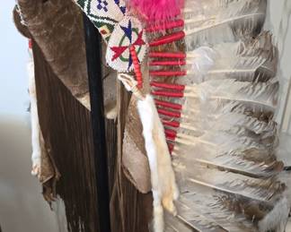 Exceptional full-size Plains-style feather warbonnet/headdress, extensively hand constructed with an aged hide skullcap and long hide trailers, intricate multicolor glass seed-beadwork, distinctive polychrome trade beads, individually wrapped feather shafts, long hide fringe and fur drops. The hide and construction exhibit significant age, oxidation, wear and patina throughout. Current examination suggests the piece may date to the late 19th or early 20th century. Precise age and Plains cultural attribution are presently being researched, with additional information to follow.