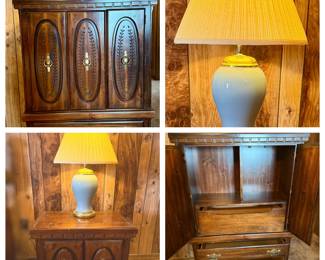 This traditional-style armoire or gentleman's chest features richly finished dark wood with two carved oval door panels accented by laurel leaf relief and brass drop-ring hardware, plus a dentil molding detail along the top rail. The interior opens to reveal an upper shelf compartment and three pull-out drawers with ornate brass bail pulls. Included is a blue-gray ceramic ginger jar table lamp with gold-tone accents and a pleated fabric shade. The chest shows light surface wear on top consistent with age, and the lamp appears in clean, displayable condition.