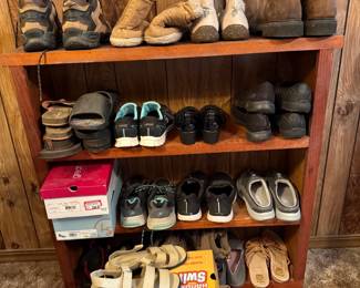 Women's Shoe Collection Lot — Boots, Sneakers, and Sandals This women's shoe lot includes multiple pairs displayed on a bookshelf: hiking-style boots, winter boots, athletic sneakers, casual shoes, and sandals. A Skechers shoe box is visible in the lot, and styles range from practical outdoor footwear to everyday walking shoes. A bulk women's shoe lot with variety across seasons and activities — sizes should be confirmed in person.