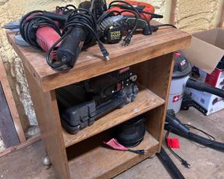 Corded Sanding and Sharpening Tool Lot in Rolling Wood Cart This lot includes a collection of corded sanding and sharpening tools stored on a rolling wood workshop cart: a belt sander, a palm sander, an orbital finishing sander, and what appears to be a knife and tool sharpener. All tools are corded models showing honest workshop use. A practical sanding tool assortment for furniture refinishing, woodworking prep, and blade maintenance, with the rolling cart included for shop-floor mobility. Working condition not confirmed on all items — sold as found.