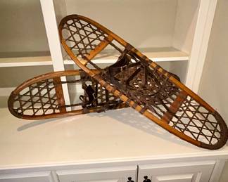 Vintage wood-frame rawhide snowshoes with leather bindings