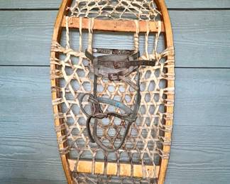 Vintage wood-framed rawhide snowshoe with leather bindings